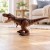 Ilustracja: dinozaur T-Rex na podłodze, strzałki pokazują ruch głowy i łap