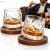 Dwie obrotowe szklanki do whisky z młotkowanego szkła na drewnianych podstawkach, w tle mężczyzna