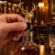 Dłoń wciska karbowany korek nalewaka jeleń w szyjkę karafki z whisky